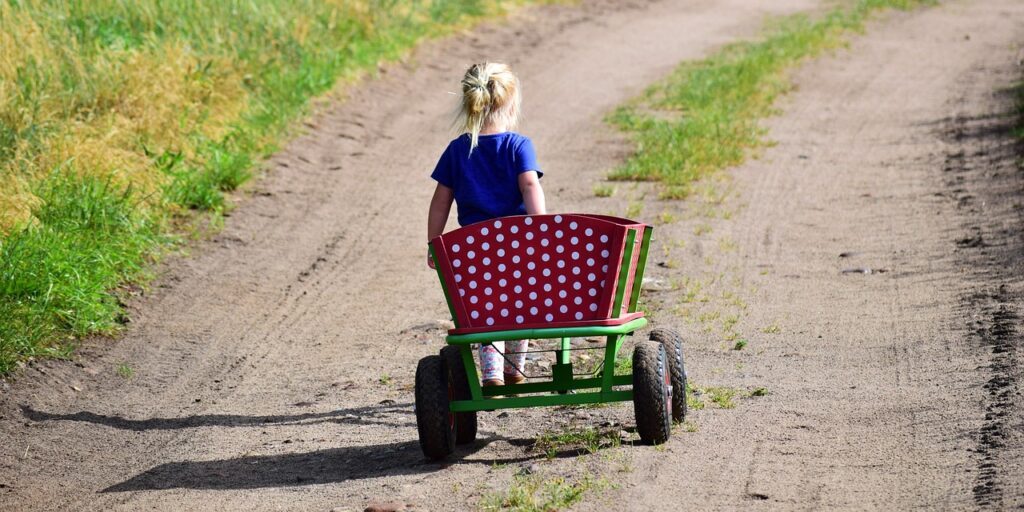 Child walking away pulling a wagon